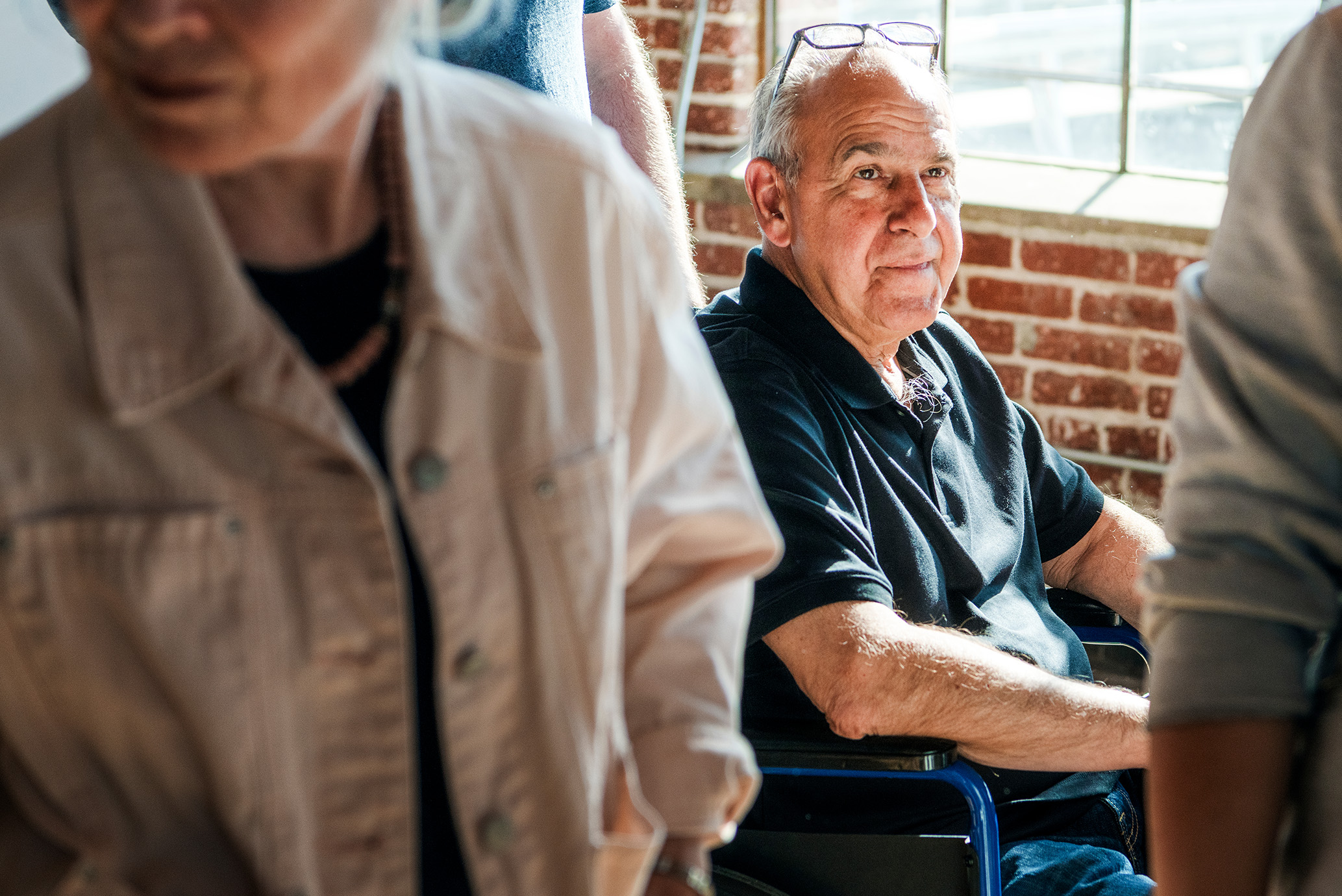 Elderly man in a wheelchair at a gathering